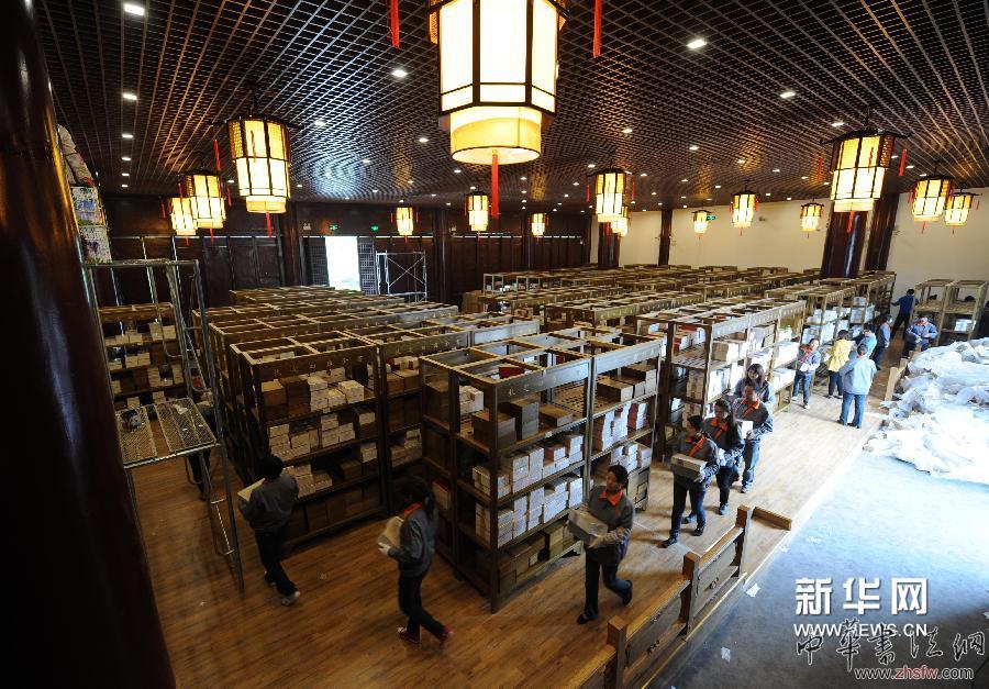 4月16日，在扬州天宁寺万佛楼的《四库全书》首套复制件布展工作现场，工作人员将书册搬运到楠木书架上。