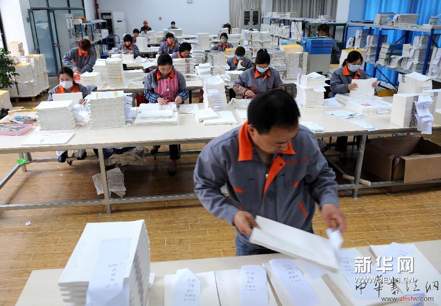 4月16日，装订车间工人在进行《四库全书》装订工作。