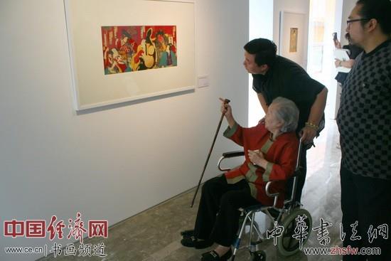邹佩珠和游客们在现场观展 中国经济网记者李冬阳摄